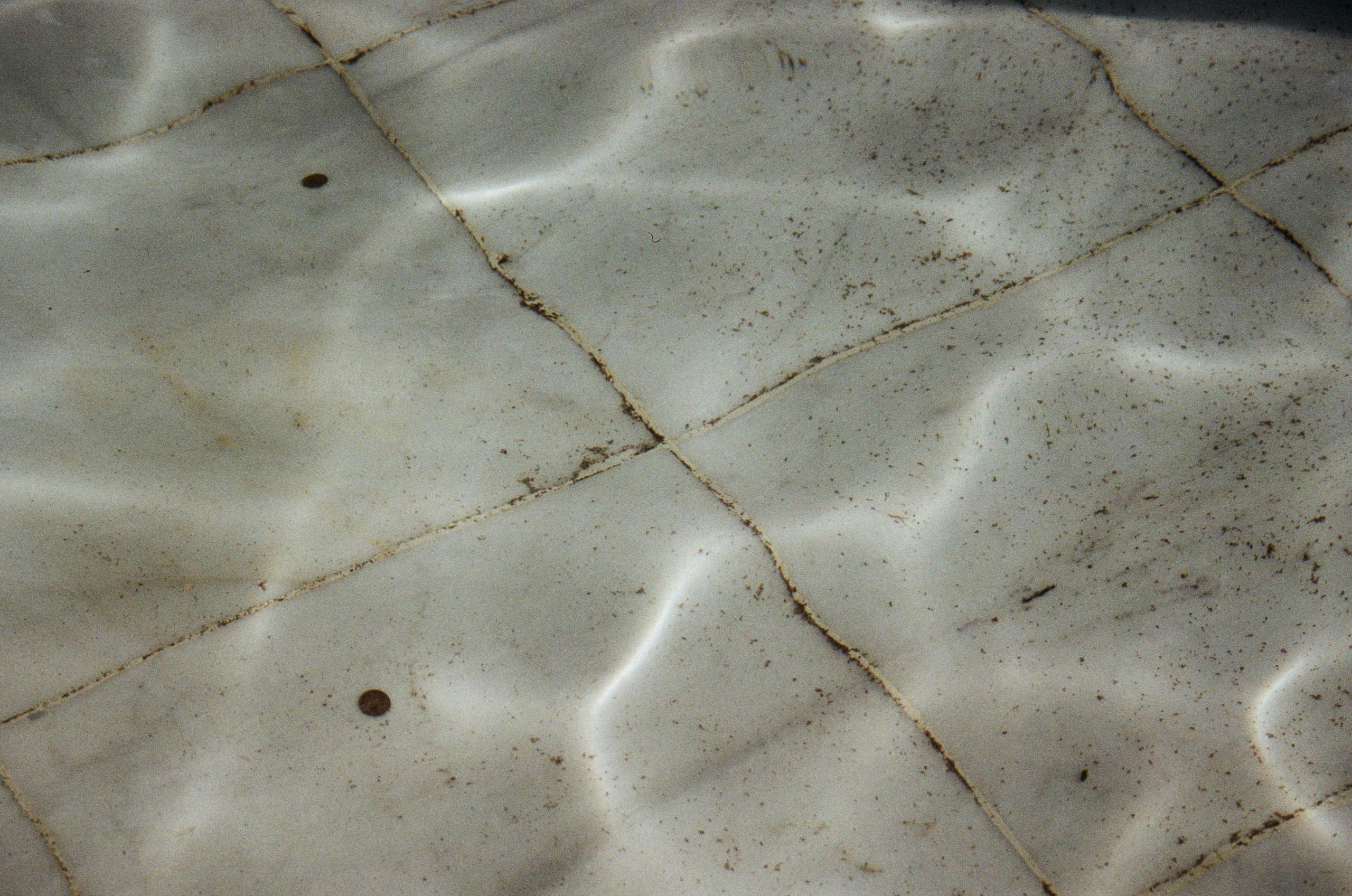 dirty grout on a tiled surface under water